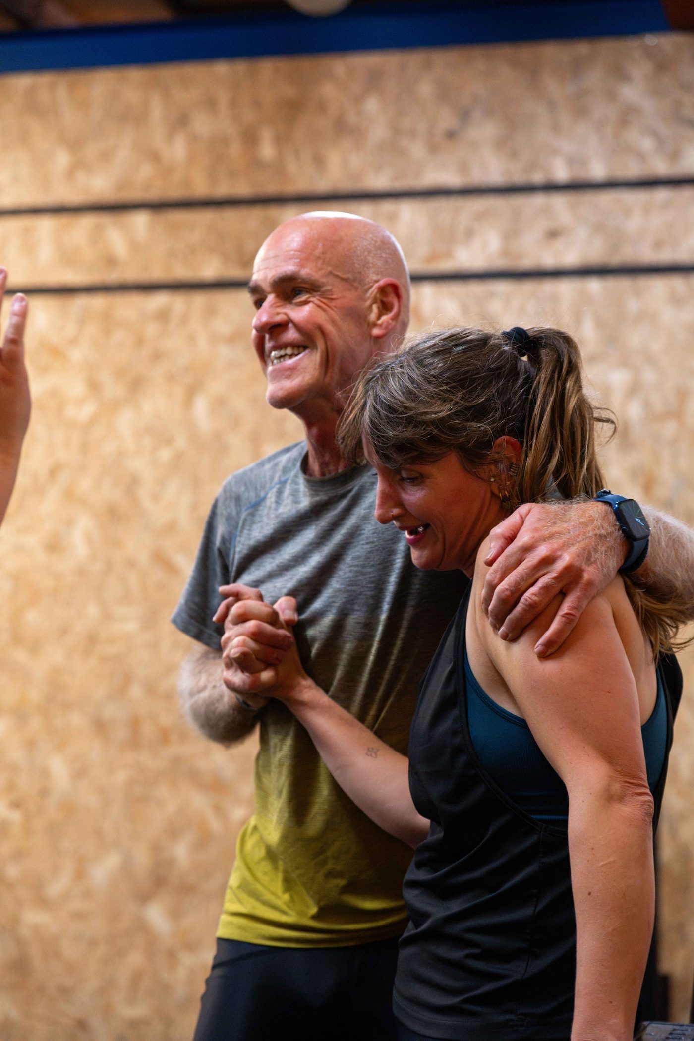 Twee leden van CrossFit Alkmaar vieren lachend samen de finish van een workout