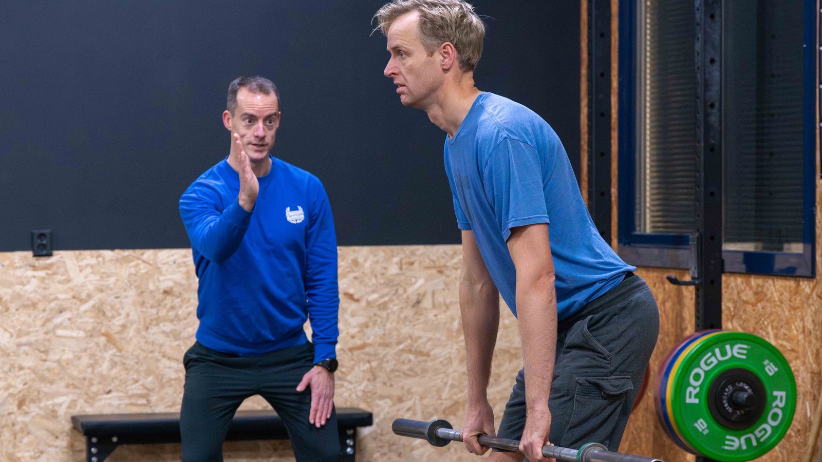 Coach geeft techniekaanwijzingen aan een atleet met de barbell tijdens de Oly Cursus bij CrossFit Alkmaar